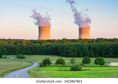 Steaming Cooling Towers at Nuclear Power Plant around Sunset