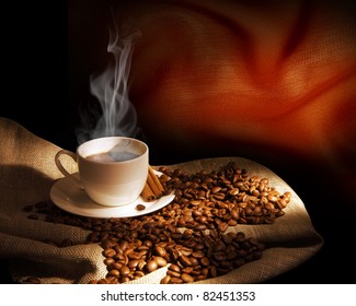 Steaming cup of coffee, cinnamon sticks and a few coffee beans. still life - Powered by Shutterstock