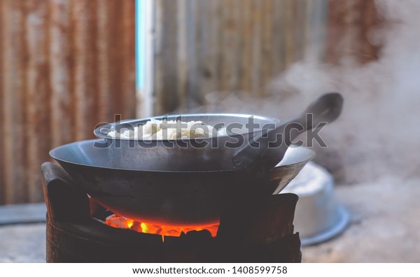 Steaming food on a charcoal\
stove.