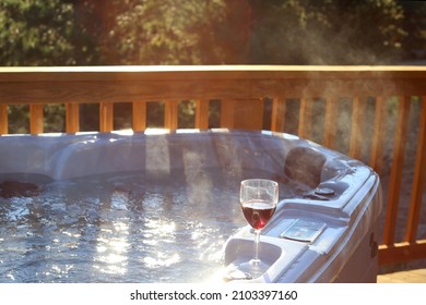 Steaming hot tub on the deck with wine glass - Shutterstock ID 2103397160