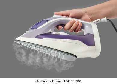 Steaming iron in hand
Holding a modern iron expelling hot steam through bottom jets