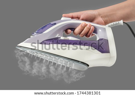 Steaming iron in hand
Holding a modern iron expelling hot steam through bottom jets