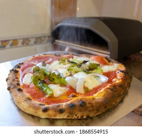 Steaming Pizza In Front Of A Gas Oven