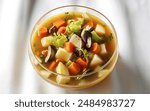 a steaming vegetarian vegetable soup with sliced mushrooms, served in a clear glass bowl