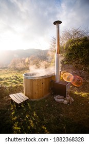 Steaming Wooden Hot Tub Warmed Up By Fire Wood, Set Up In Nature. Off Grid Campground Living Lifestyle. Country House Or Cabin In The Woods. Relaxation And Peace, Mindfulness Resort