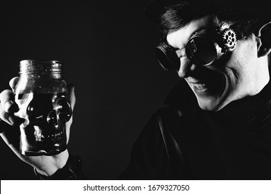 Steampunk actor in glasses and hat posing