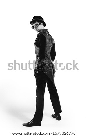 Steampunk actor in glasses and hat posing