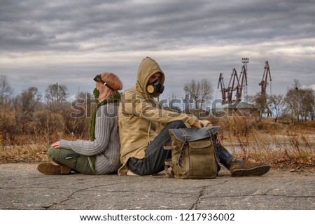 Steampunk or cyberpunk style adventurers couple, woman in goggles and neckerchief half face mask, man in hood and respirator gas mask, rest on the ground leaning back against each other