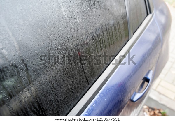 Steamy car window on a autumn rainy/foggy day.\
Concept of safety driving\
problem.