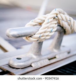Steel anchor on boat or ship/ White mooring rope tied around steel anchor