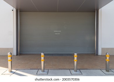 steel bollards with yellow reflec strip in front of the shuter door of shop.