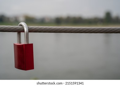 Steel Cable From A Railing On The Bridge With An Attached Red Padlock