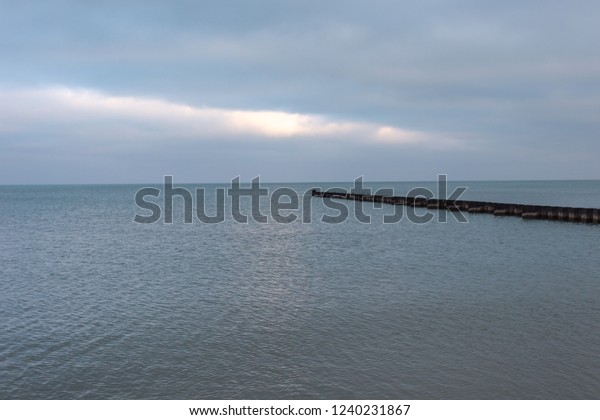 Steel divider as leading line on Lake Michigan on\
cloudy day