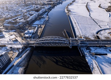 Steel draw bridge over river IJssel   white floodplains Dutch Hanseatic medieval tower town Zutphen  The Netherlands  Aerial cityscape after snowstorm  Climate   weather condition concept