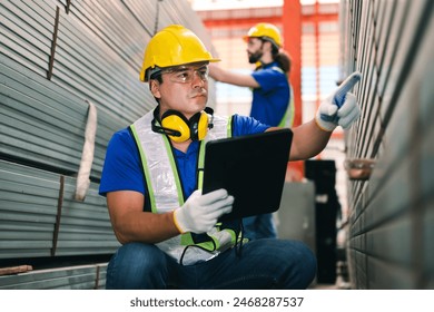 Steel factory workers using tablet check stock of steel tubes at the product placement point in iron factory. - Powered by Shutterstock