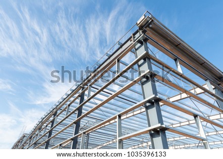 steel frame workshop is under construction against a blue sky