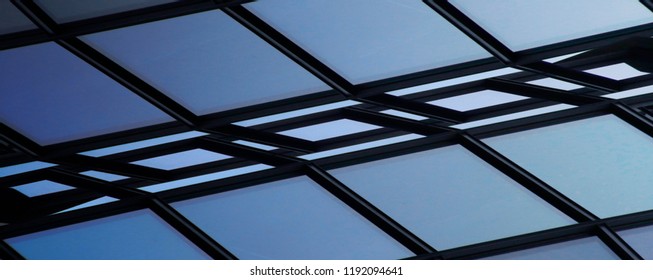 Steel and glass. Reworked close-up photo of office building fragment. Glass structure with metal framework and sky visible outside. Abstract modern architecture or technology background. - Shutterstock ID 1192094641