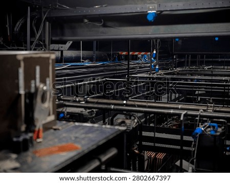 Steel grid, scaffolding and cabling in the technical understage of a theater, the complex metal substructure supporting the stage