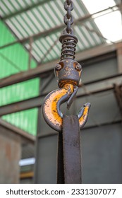 the steel Hook of lifting hoist holding a strip