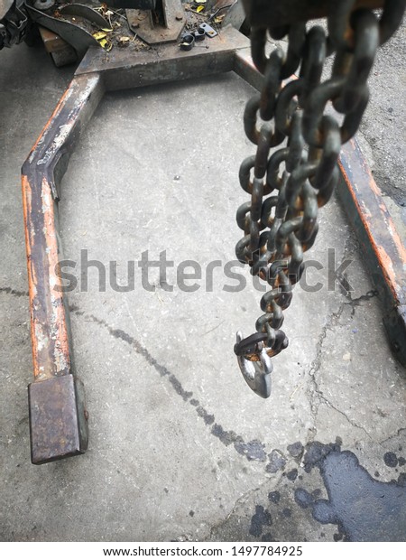 Steel hooks on steel chains, used for lifting\
and hauling heavy items in\
garages.