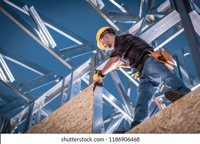 Steel House Constructor Worker. Caucasian Worker With Power Tool On The Building Frame.