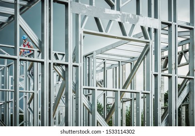 Steel House Frame Development. Caucasian Construction Contractor Wearing Safety Harness Working On The Frame.