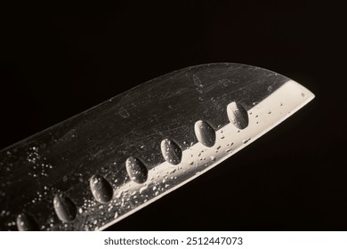 a steel knife covered with water droplets on a blackboard background, close up - Powered by Shutterstock