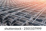 Steel Mesh Reinforcing Construction Material Background, Pile of Black Wire Reinforcement Iron Grid Square Shape Stacked on the Floor in Industry yard area with Light Reflection on surface 