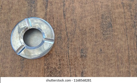 Steel Metal Empty Ashtray On A Beige Table. View From Above.