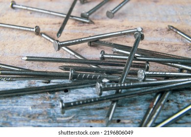 Steel Nails Spread Over A Reclaimed Wood Table. Steel Woodworking Nails Lying Ona A Table Made Of Old Vintage Reclaimed Wood. Top View.