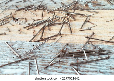 Steel Nails Spread Over A Reclaimed Wood Table. Steel Woodworking Nails Lying Ona A Table Made Of Old Vintage Reclaimed Wood. Top View.