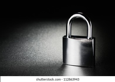 Steel padlock on the black textured background
