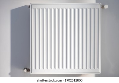 A steel panel heating radiator is placed on a white wall.