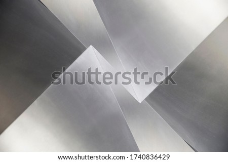 Steel panels or sheets. Abstract modern architecture exterior or interior detail. Industrial background in hi-tech style. Polygonal geometric structure in shades of metallic gray color.