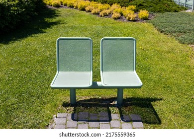 Steel park bench. View of a modern green bench in the park, summer time