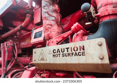 Steel plate "Hot surface" caution sign on the heavy pumping unit machinery for operating in refinery industrial. Industrial safety equipment and symbol object. - Powered by Shutterstock