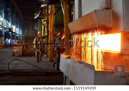 Steel quenching at high temperature in industrial furnace at the workshop of a forge plant. Process of cooling, heat treatmen. Blacksmith and metallurgical industry, steelmaking, hot rolling mill 商業照片 © 