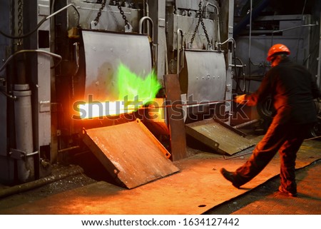 Steel quenching at high temperature in industrial furnace at the workshop of a forge plant. Process of cooling, heat treatmen. Blacksmith and metallurgical industry, steelmaking, hot rolling mill 商業照片 © 
