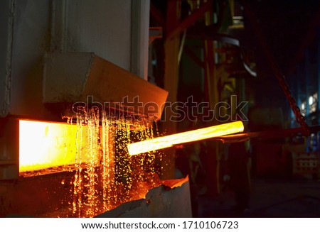 Steel quenching at high temperature in industrial furnace at the workshop of a forge plant. Process of cooling, heat treatmen. Blacksmith and metallurgical industry, hot rolling mill. Small sharpness