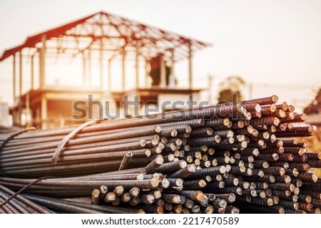 steel rebar for reinforcement concrete at construction site with house under construction background