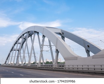 Steel Riveted Arch Of The Combined Road And Railroad Bridge Against The City Buildings
