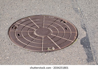 Steel round manhole cover for a manhole on an asphalt road.
