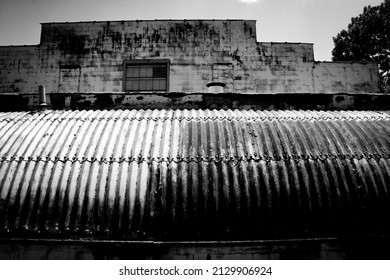 a steel rusting quonset hut farm industrial building rundown abandoned closed small town closure black and white factory