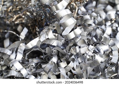 Steel scrap materials recycling. Aluminum chip waste after machining metal parts on a cnc lathe. Closeup twisted spiral steel shavings. Small roughness sharpness, - Shutterstock ID 2024036498