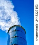 Steel smoke stack against a blue sky.