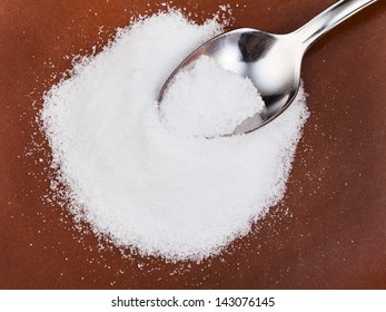 Steel Spoon In Handful Of Crystalline Fructose Close Up