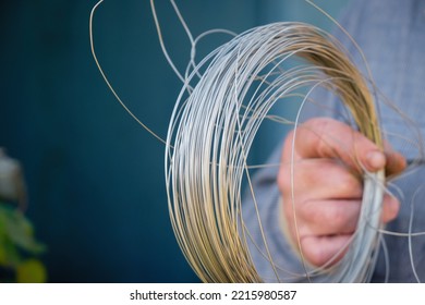 Steel Stainless Wire Roll For Homework In Man's Hand. Copy Space.