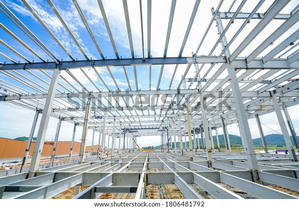 Steel structure roof truss frame and steel structure\
mezzanine floor under the construction building with blue sky      \
    
