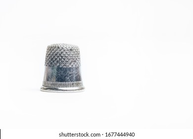 Steel thimble for sewing on a white background.