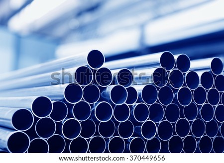 Steel tubes against industrial blurred background